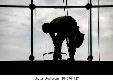 Worker Silhouettes Cleaning Windows On Height, Cleaning Building Window Glass. Cleaning Windows From The Inside.