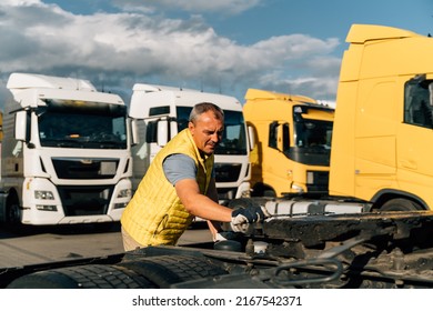 A Worker Smearing Trailer Fifth Wheel Coupling With Lubricant Oil. Semi-truck Mechanical Maintenance 