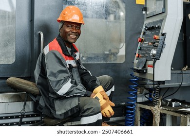 Worker smiling while operating industrial machinery wearing protective gear Equipment and controls are visible with clear focus on worker's expression and attire - Powered by Shutterstock