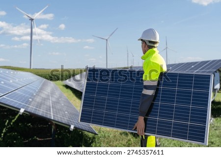Worker with solar panel on a background of solar power station	