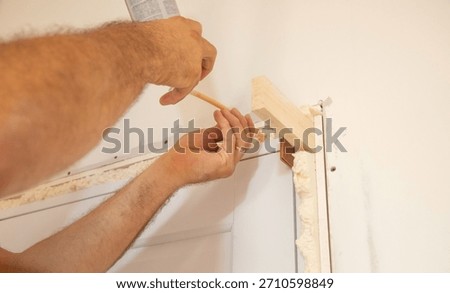 Worker spray construction foam between new door.