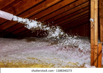 Worker Spraying mineral rock wool of house attic insulation