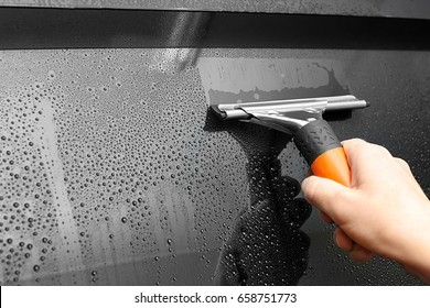 Worker With Squeegee Washing Tinted Car Window