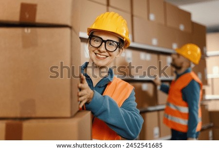 Worker stacking cardboard delivery boxes at the warehouse: logistics and delivery service concept