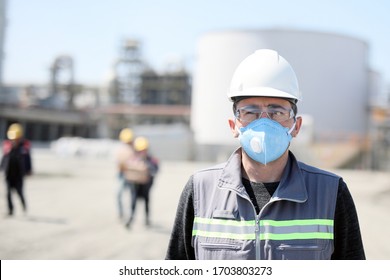 The Worker (staff, Engineer) Protects Himself From Covid-19 (coronavirus) With A Protective Mask In The Construction Site.