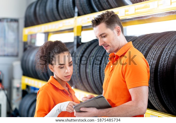 worker staff man and woman\
checking stock of Car tires at showroom tires and wheel. Concept\
factory of equipment for repair and replace Automotive business\
industry.