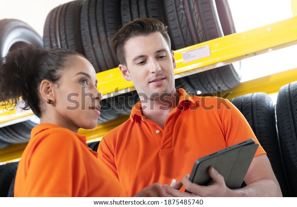 worker staff man and woman\
checking stock of Car tires at showroom tires and wheel. Concept\
factory of equipment for repair and replace Automotive business\
industry.