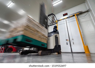 Worker Stand-on Stacker Truck Used To Lift And Move The Ready Meals Goods Stock In Cold Room Or Freezer Room.