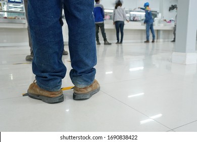 Worker Stands Before The Yellow-black Line Up To Wait To Buy Food In The Factory Canteen Room During Corona Virus Epidemic. (Covid 19)