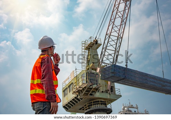 worker stevedore foreman, engineering, loading master talks to crane ...