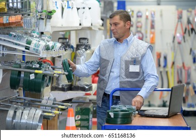 Worker Stocking Shelves In Hardware Store