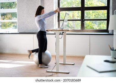 Worker Stretch Exercise At Stand Desk In Office - Powered by Shutterstock