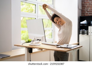 Worker Stretch Exercise At Stand Desk In Office - Powered by Shutterstock