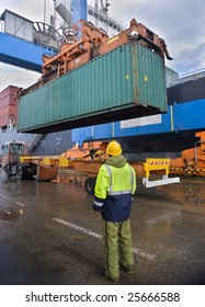 worker supervising container uploading at dock