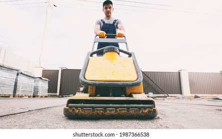 The Worker Tamping A Gravel By The Vibration Plate