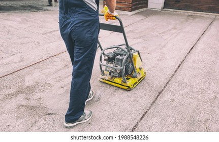 The Worker Tamping A Gravel By The Vibration Plate