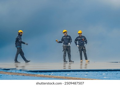 Worker Technicians are working to construct solar panels system on roof. Installing solar photovoltaic panel system. Men technicians walking on roof structure to check photovoltaic solar modules.