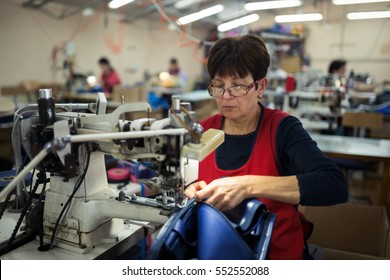 Worker In Textile Industry Sewing On Machine