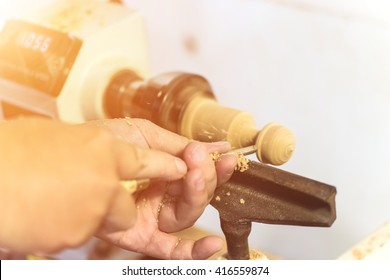 Worker Turning Wood On A Lathe