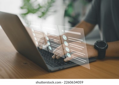 A worker types on a laptop keyboard into a document management system (DMS) or database, which is the concept of using technology to effectively manage files and document storage in digital format. - Shutterstock ID 2260634059