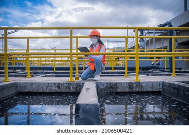 Worker Under Checking The  Waste Water Treatment Pond Industry Large To Control Water Support Industry ,wearing Mask For Protect For Virus And Pollution.