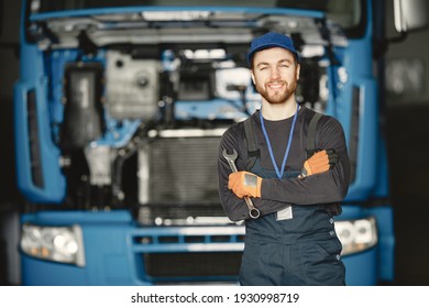 Worker In Uniform. Man Repairs A Truck. Man With Tools