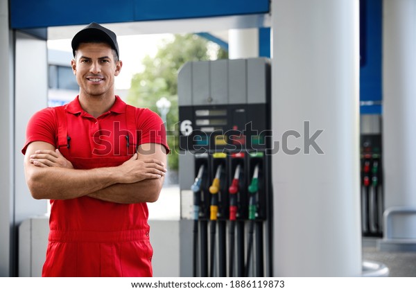 Worker in uniform at\
modern gas station