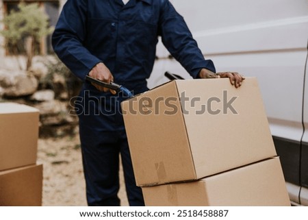 Worker unloading boxes, removal service job. Boxes being delivered, home delivery. Cardboard boxes being delivered to home. Service and small business concept.