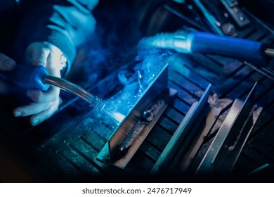 Worker use weld metal welding machine in workshop, blue sparks. - Powered by Shutterstock