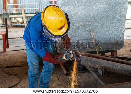 Worker is used Grinding Machine to grinding surface of H-Beam steel after cutting, at Industrial factory.