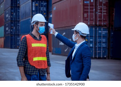 The Worker Used A Medical Digital  Temperature Thermometer To Check Staff Body Temperature Before Start Work In Factory ,they Wearing Face Mask The Concept Of A Corona Virus [Covid-19] Screening.