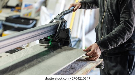 A worker uses a tile cutter to precisely cut a tile for a home renovation project