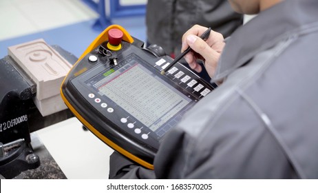 Worker uses touch control panel. Scene. Skilled worker uses electronic control panel in modern enterprise. Close-up of worker setting tasks on electronic control panel
