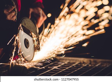 Worker Using Angle Grinder in Factory and throwing sparks