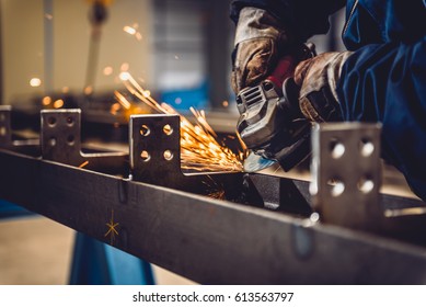 Worker Using Angle Grinder in Factory and throwing sparks