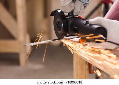 Worker Using Angle Grinder in Factory and throwing sparks.
