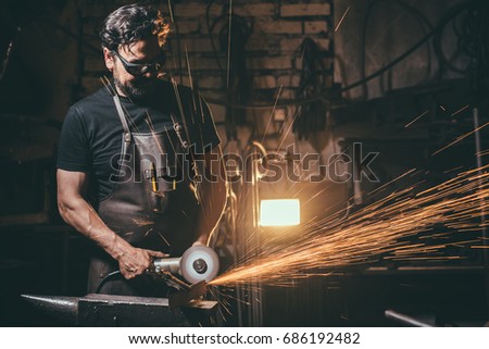 Worker Using Angle Grinder in Factory and throwing sparks