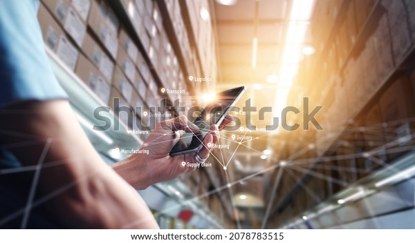Worker using application smartphone checking\
and control on global logistics network distribution, Checking\
order in large warehouse. Transportation and processing of orders\
of goods, Smart\
logistics.