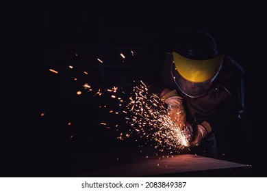 Worker using a circular saw to cut a metal plate in a factory with selective focus - Powered by Shutterstock