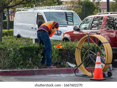 Worker Using Commercial Plumbing Snake To Clear A Drain In Parking Lot