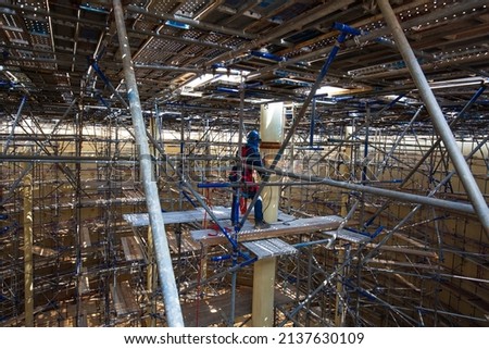 Worker using electric wheel spark grinding on welder metal carbon steel part pipe on scaffolding