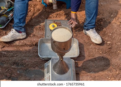 Worker using equipment for testing laboratory field density test sand cone method and soil density test of road under the construction.Soil field density test sand cone method calculation .