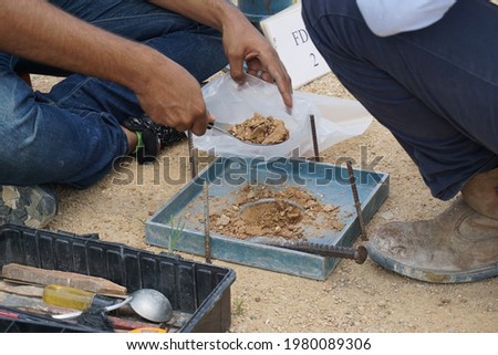 Worker using equipment for testing laboratory field density test sand cone method and soil density test of road under the construction.Soil field density test sand cone method calculation