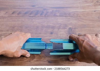 Worker using grinding machine to cut steel roof batten.