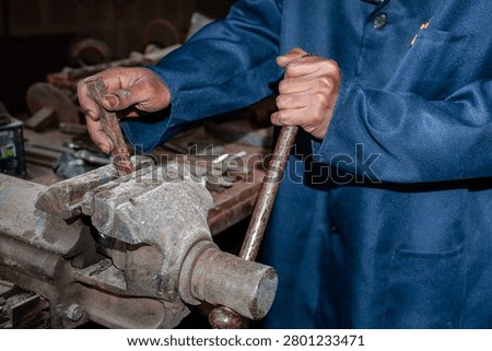 Worker using a large metal vice