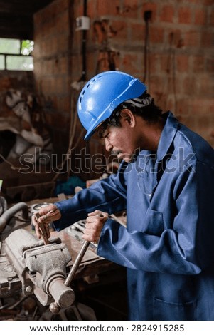 Worker using a large metal vice