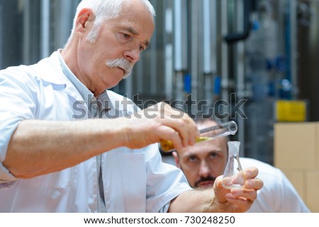 worker using to measure the specific gravity of beer