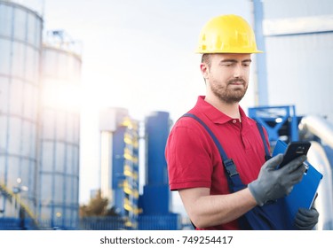 Worker Using Mobile Phone Outside Factory