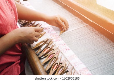 Worker using the old loom weaving machine with colorful threads to make beautiful fabric with design, pattern and clothes. Occupation and career for local people to gain more income - Shutterstock ID 1602938185