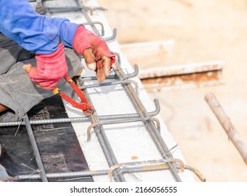 Worker Using Pliers For Bundle Of Steel Rebar For Building Structures Beams